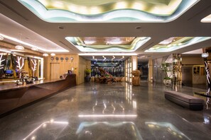A modern hotel lobby with a polished floor, a reception desk, and a central seating area. - Shianghu Boutique Hotel (Chiayi City)