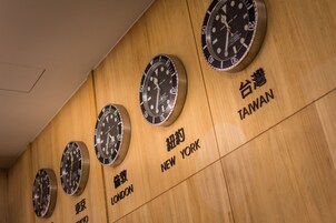 Uma parede com relógios mostrando os horários de Taipei, Nova York, Londres e Tóquio.