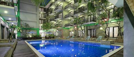 Een buitenzwembad en ligstoelen