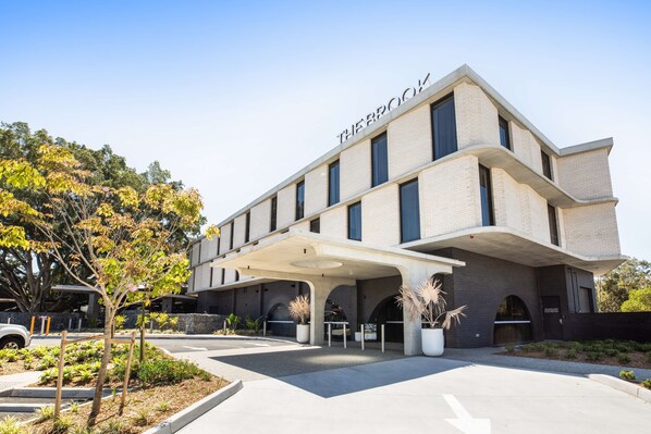 Un edificio moderno con techo plano y un letrero que dice "THE BROOK".