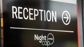 En skylt som visar var receptionen för Nightcap Hotels ligger.