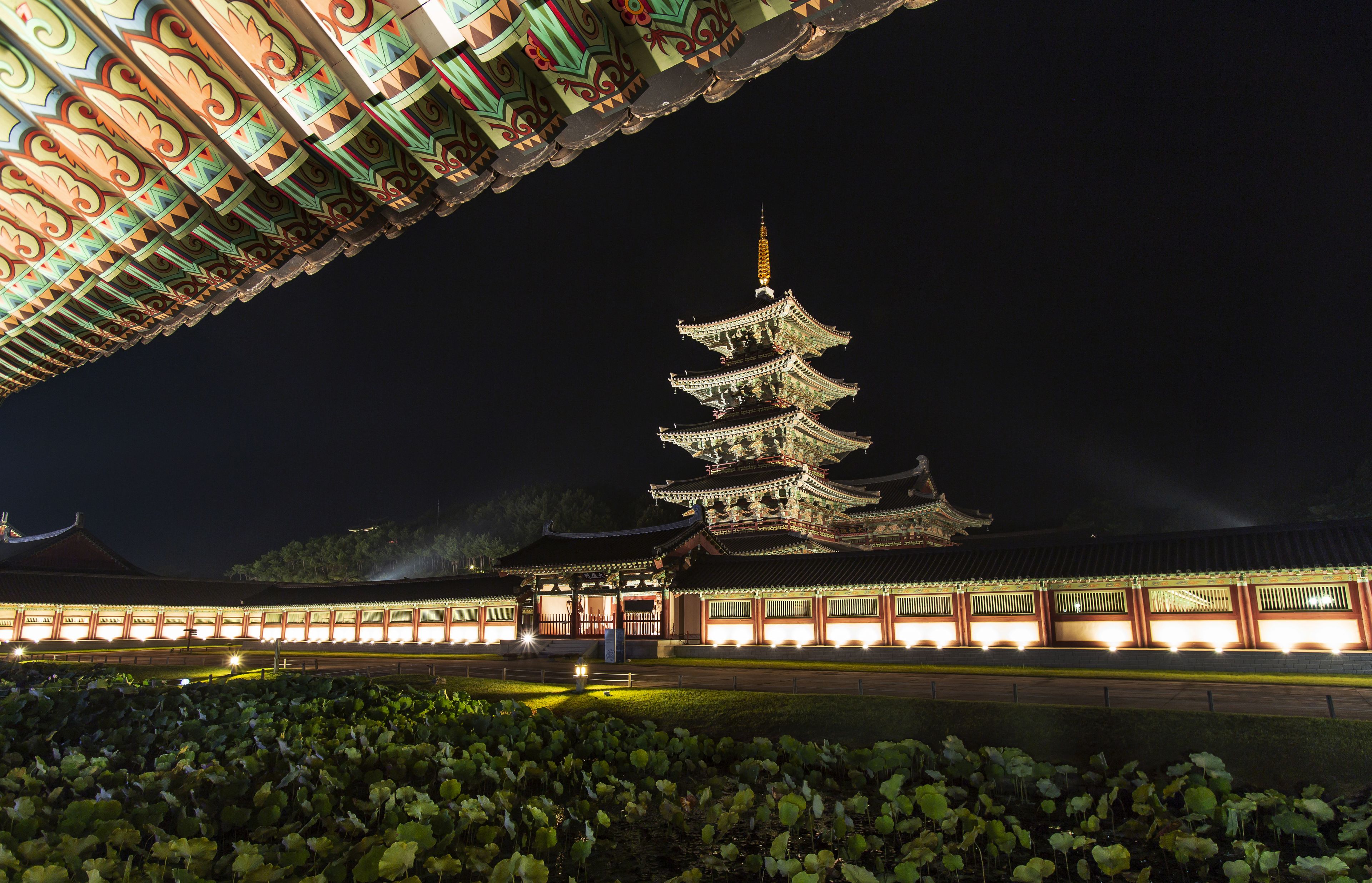 A traditional pagoda-style building with multiple tiers, illuminated by artificial lighting.