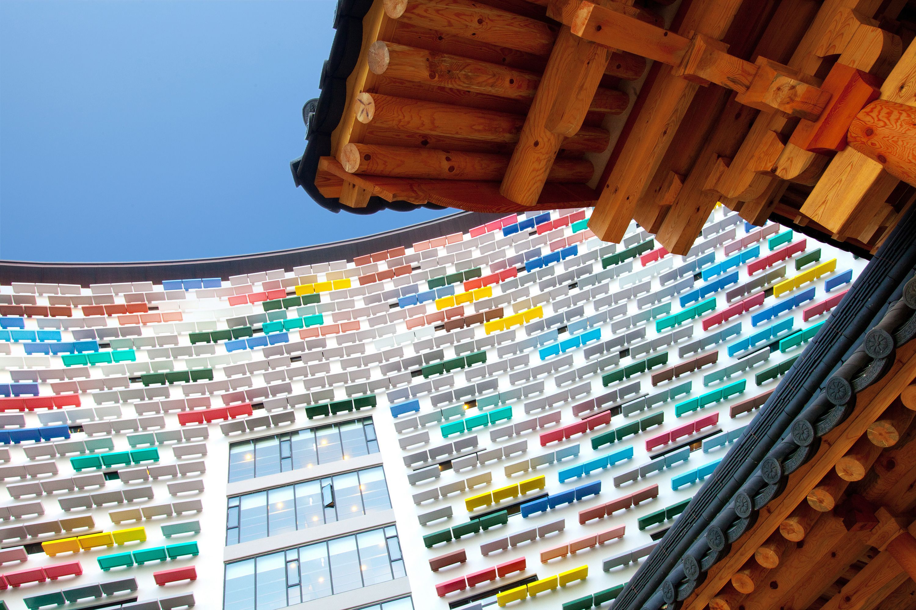 Un edificio con un diseño interior único, que presenta una pared curva con bloques rectangulares de colores dispuestos en un patrón.