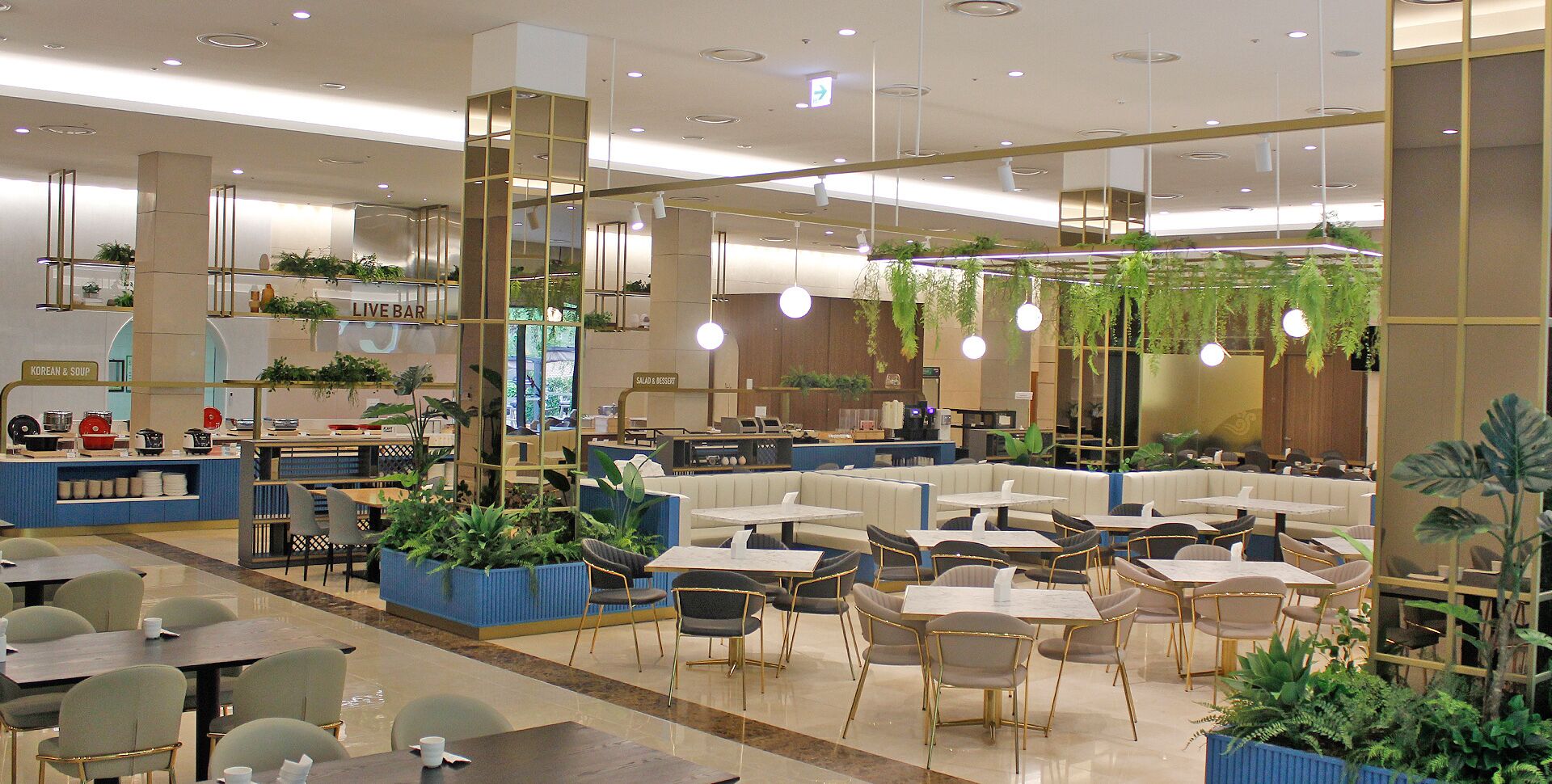 A modern restaurant with a variety of seating options, including booths and tables, and a live bar area.