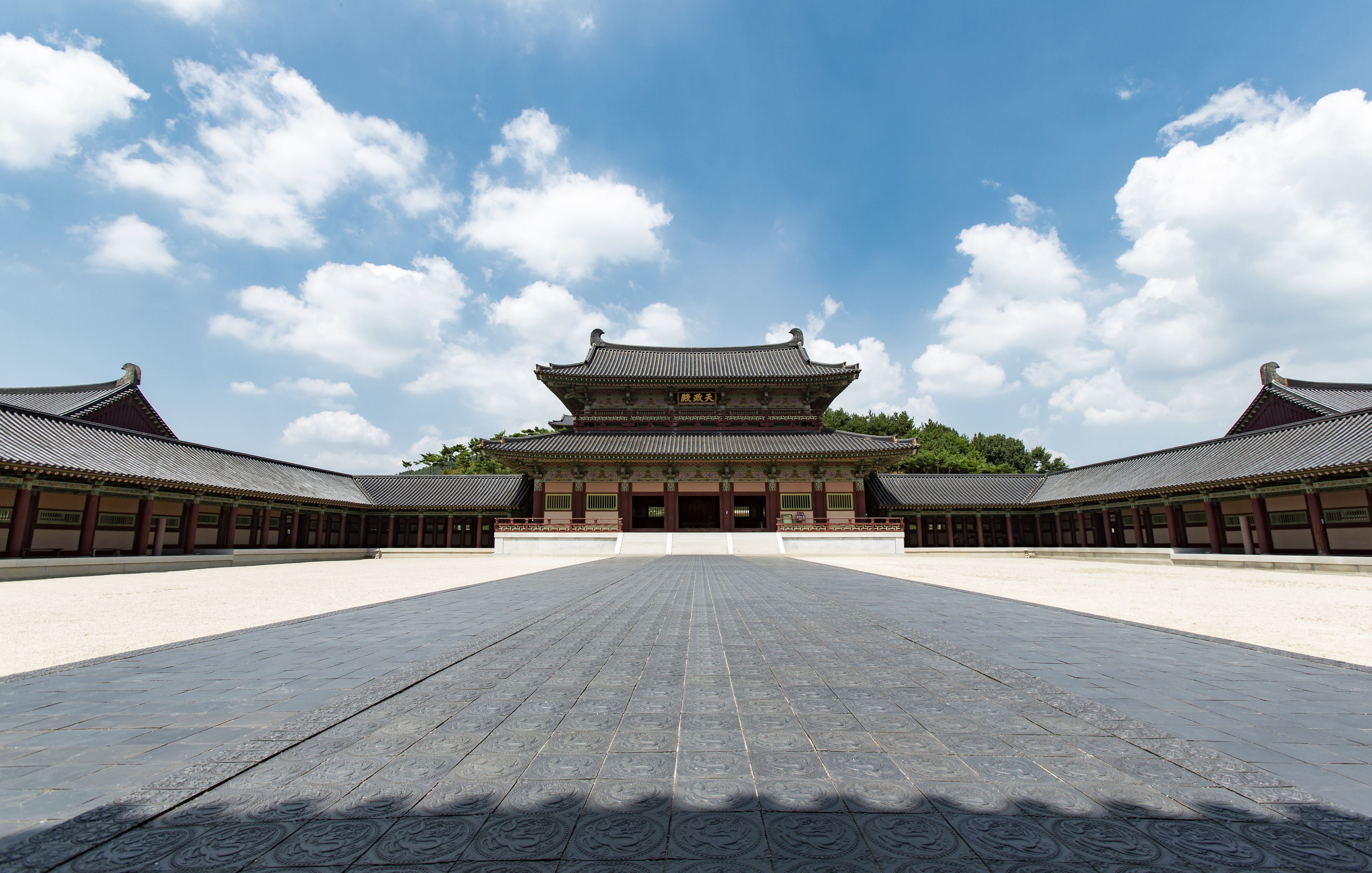 A traditional building with a symmetrical facade, large open courtyard, and a clear sky.
