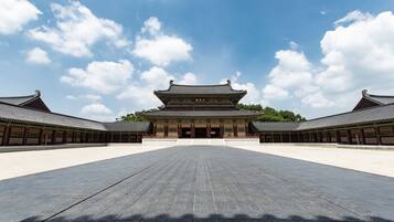 A traditional building with a symmetrical facade, large open courtyard, and a clear sky.