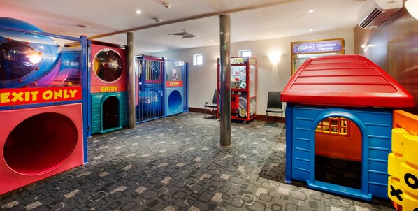 A children's play area with colorful play structures and an exit sign.