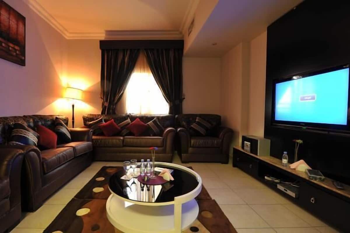 A living room with two sofas, a coffee table, a TV, and a lamp.