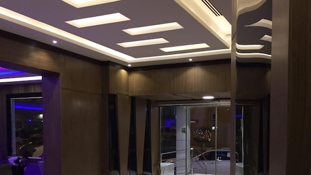 Un vestíbulo moderno con suelo de mármol, iluminación empotrada y puerta de cristal.