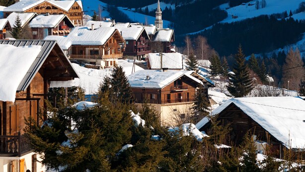 A snow-covered mountain village with wooden buildings and a church. - Résidence Lagrange Vacances Les Chalets du Mont Blanc (Hauteluce)