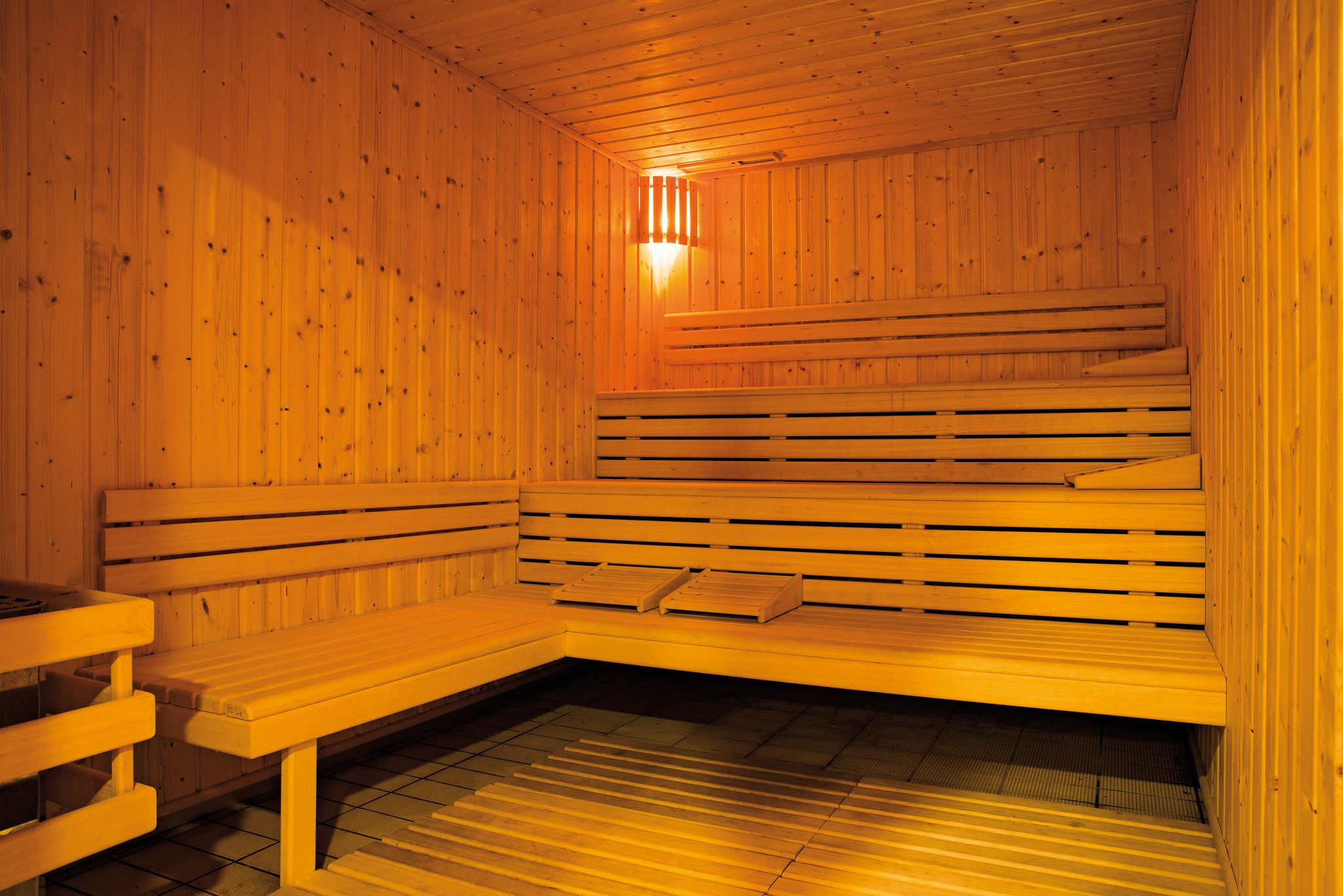 A wooden sauna with benches and a table.