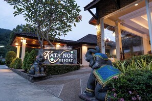 A resort entrance with a sign, two elephant statues, and a well-maintained garden. - Kata Noi Resort (Karon)