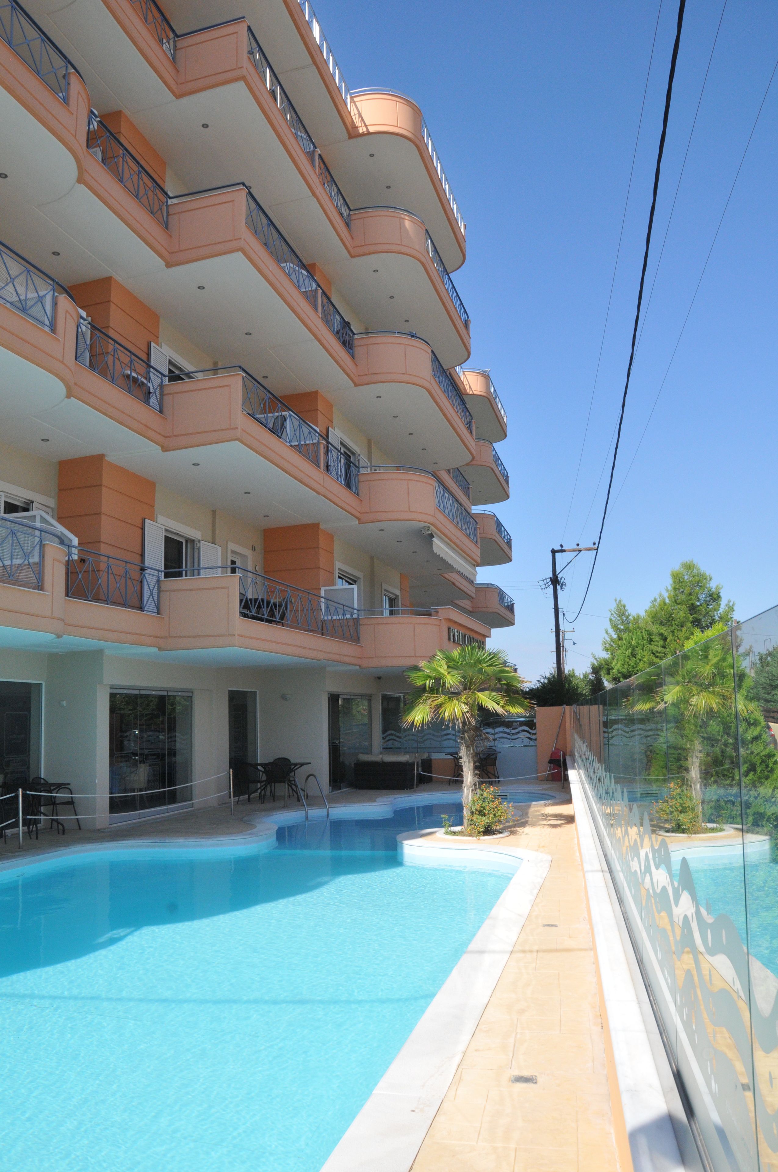 A multi-story hotel with a swimming pool, balconies, and outdoor seating.