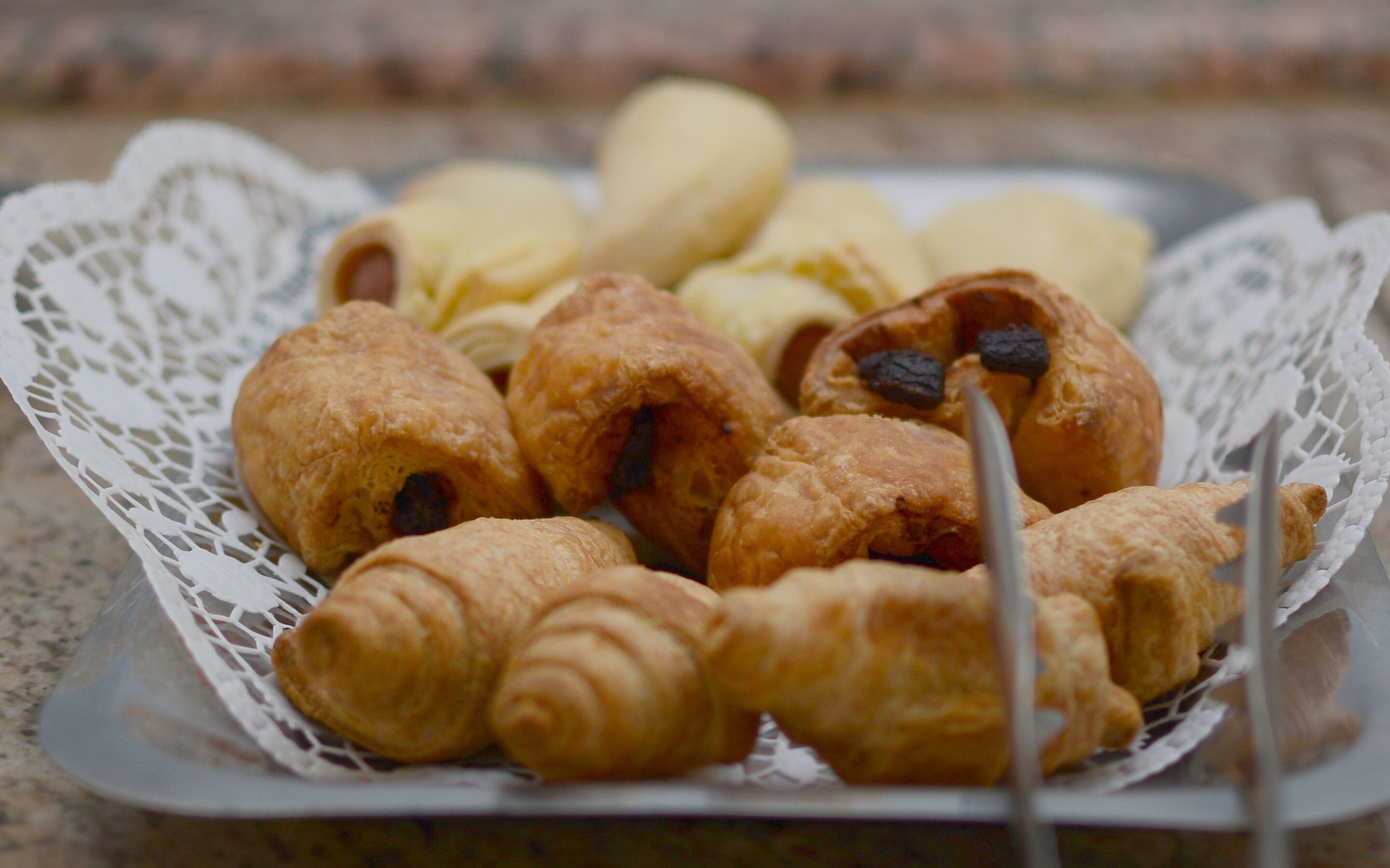 A basket of assorted pastries on a lace doily.