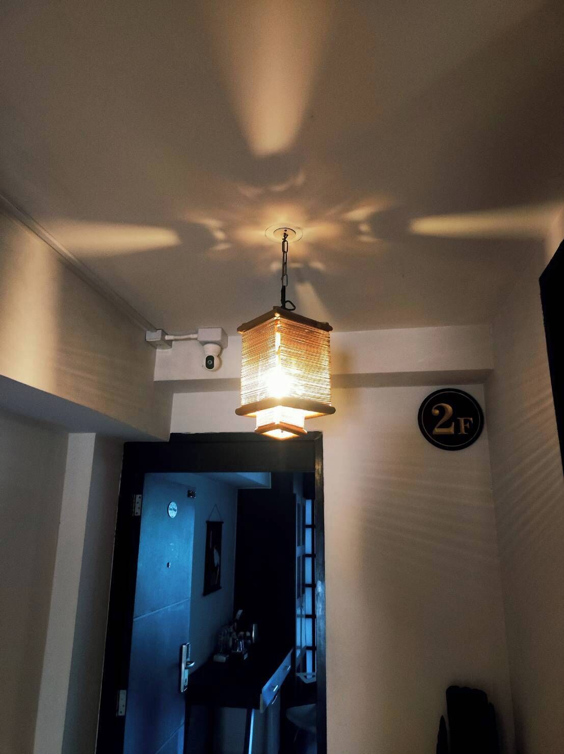A hallway with a hanging light fixture and a door marked with the number 2F.