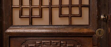 A wooden door with intricate carvings and a traditional lock mechanism.