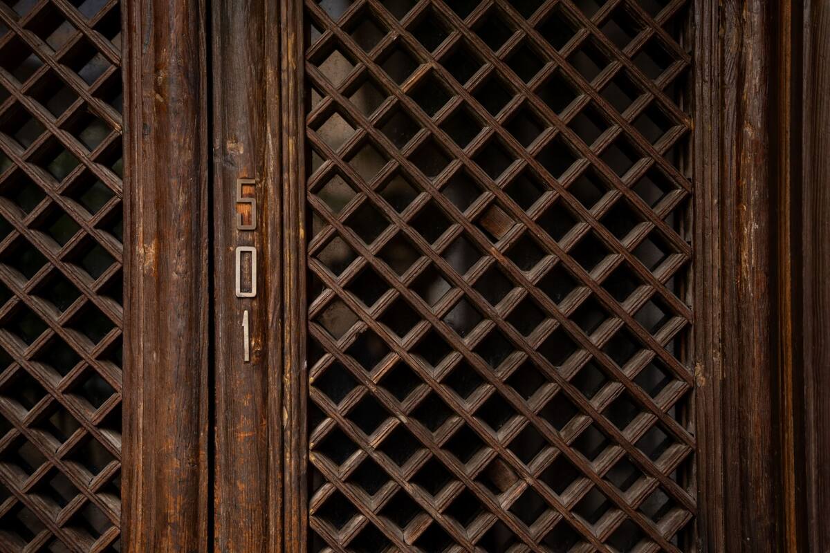 A wooden door with a metal grid pattern and a number '501' visible.