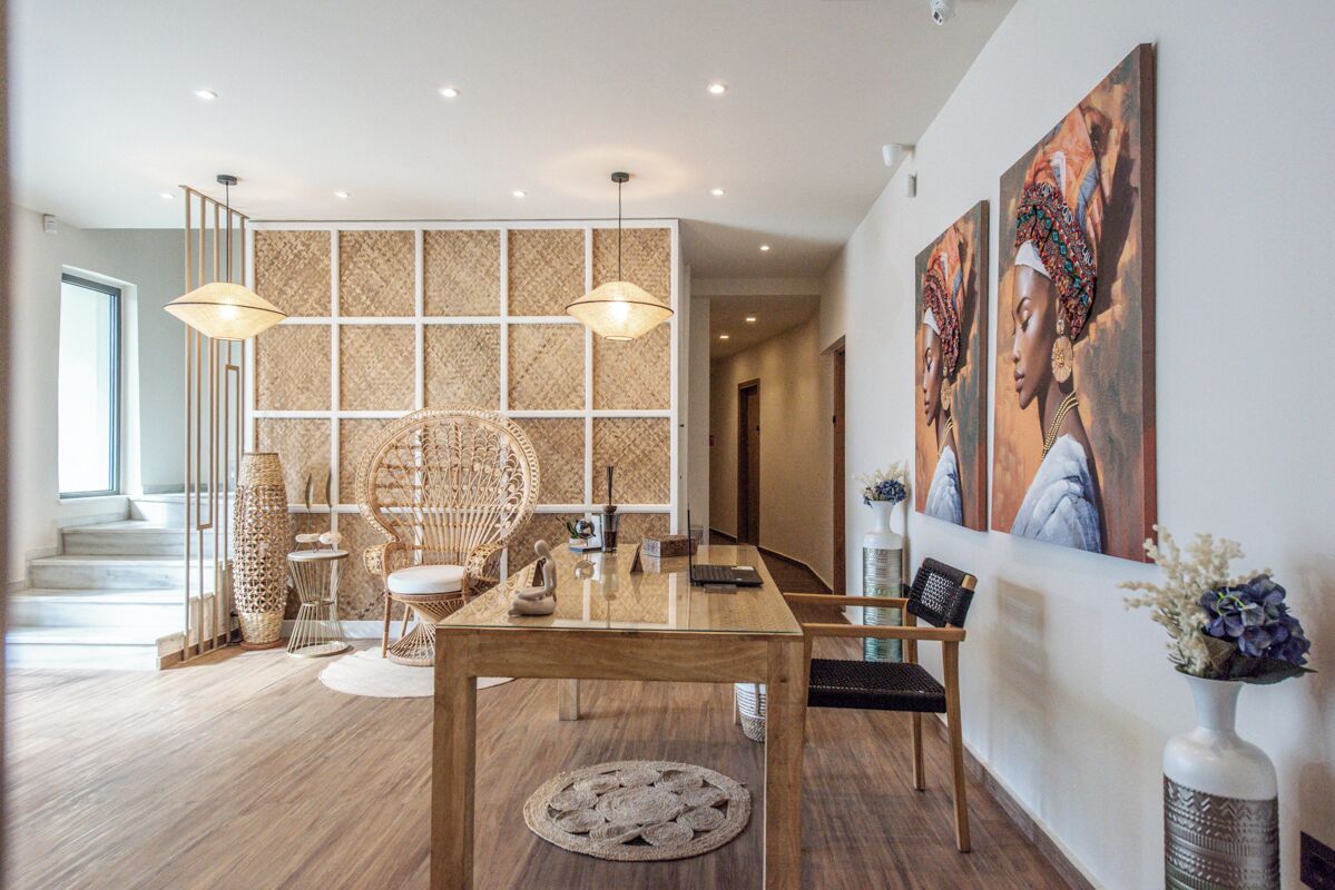 A modern dining area with a wooden table, wicker chairs, and a decorative wall panel.