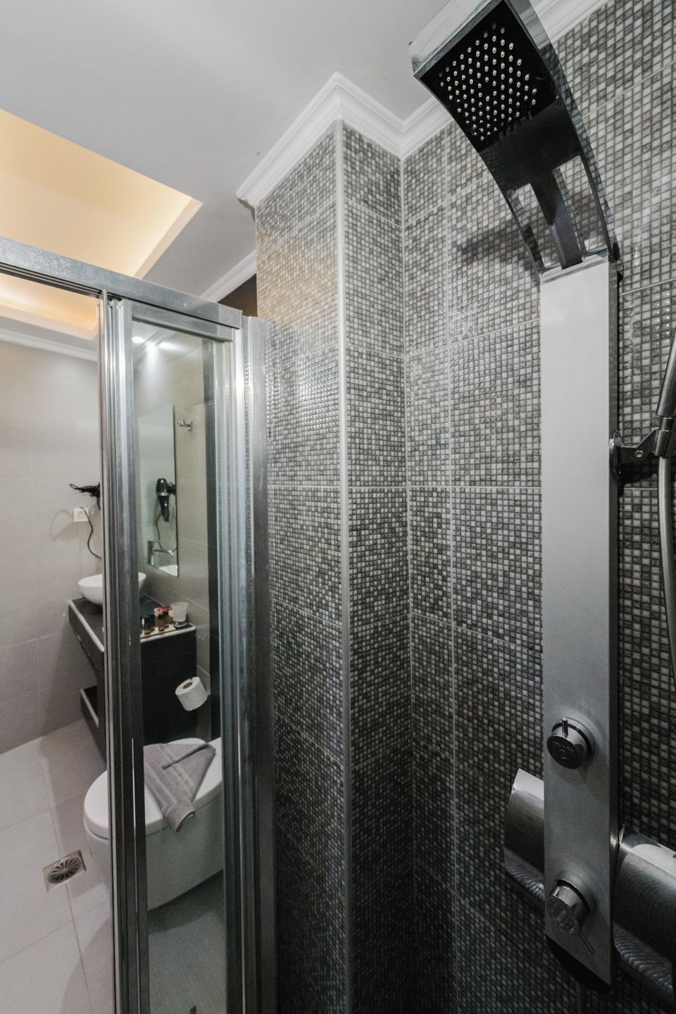 Un baño moderno con ducha envuelta en vidrio, inodoro y lavamanos.