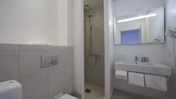 A modern bathroom with a shower, toilet, and sink.