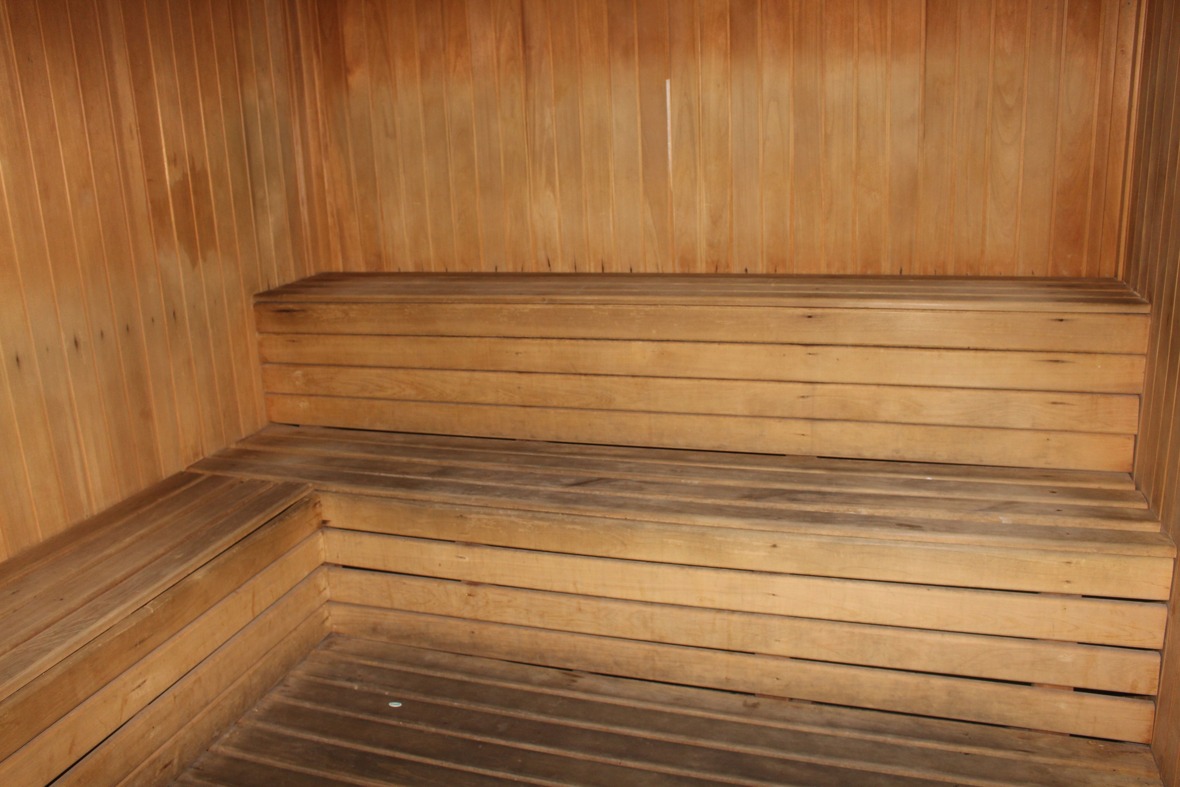 A wooden sauna with a bench and steps.