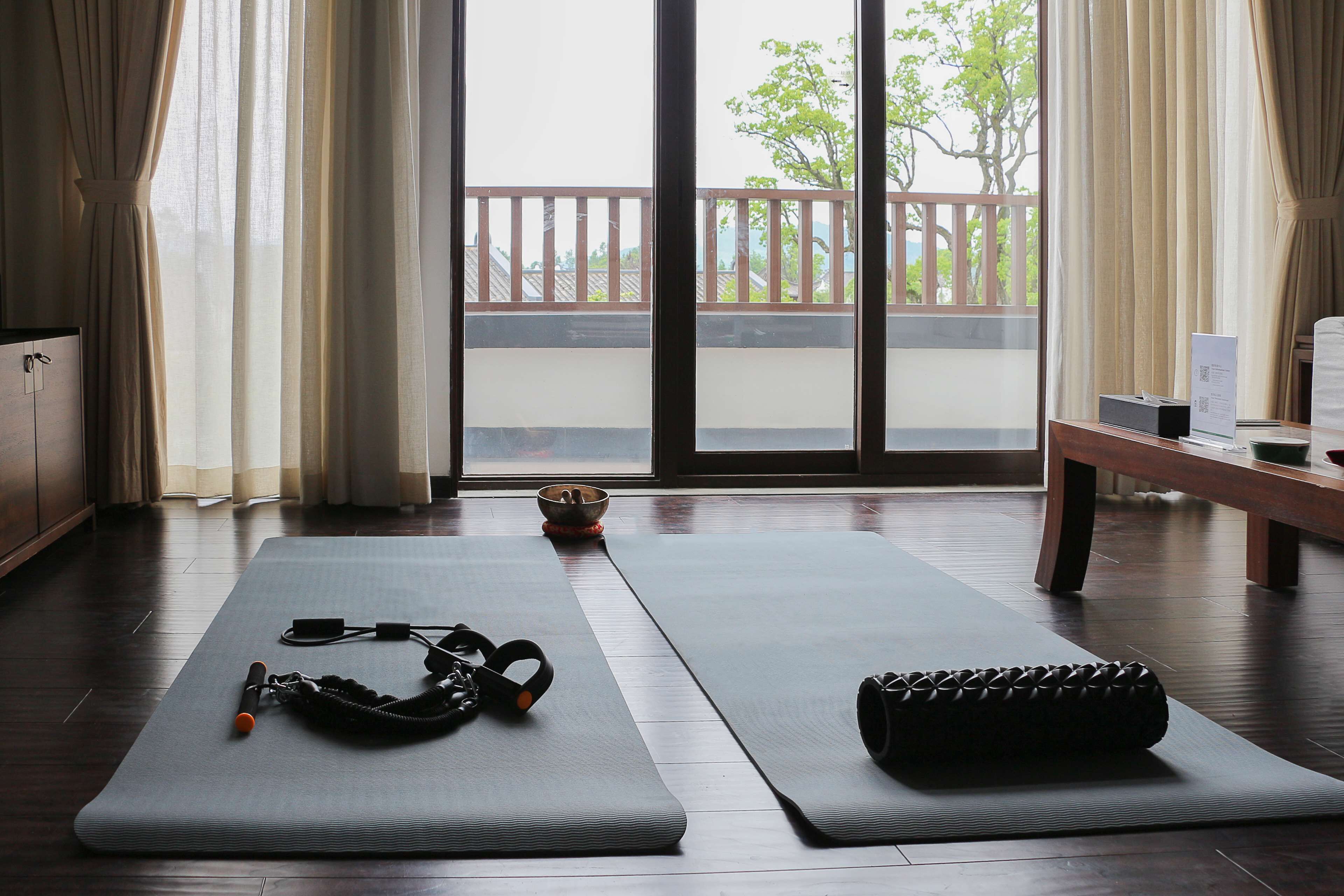 A room with two exercise mats, a yoga mat, and a kettlebell.