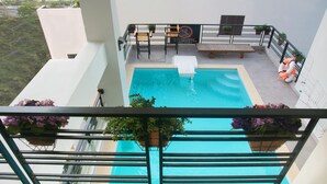 A rooftop pool with a wooden deck, potted plants, and a sign prohibiting jumping. - Pavillon Garden Hotel & Spa (Nha Trang)