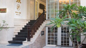 A grand entrance with a marble staircase, a large glass door, and a sign indicating the name of the establishment. - Pavillon Garden Hotel & Spa (Nha Trang)