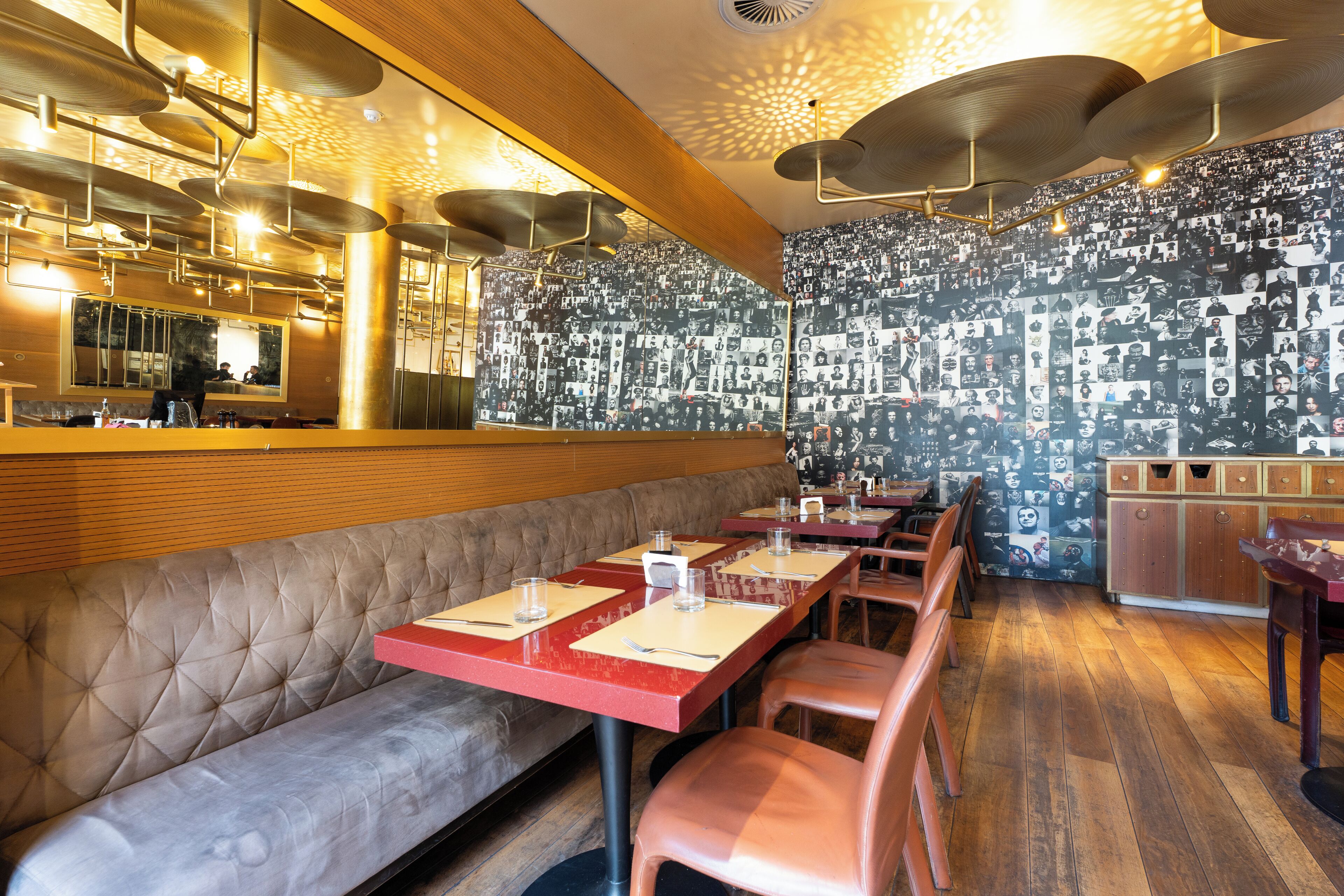 A restaurant with a bar area, booths, and a patterned wall.