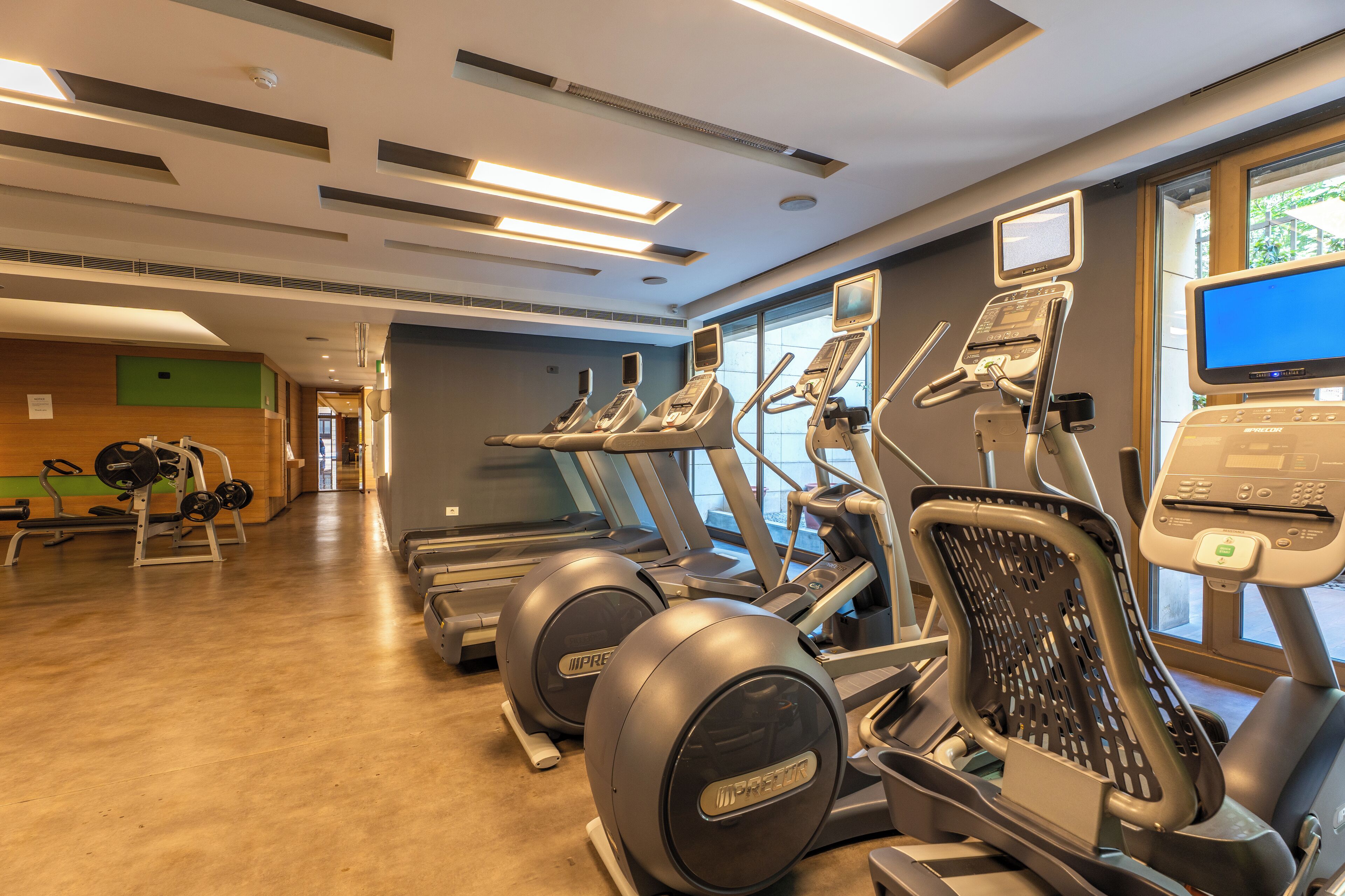 A gym with treadmills, elliptical machines, and weight equipment.