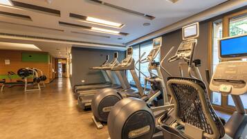 A gym with treadmills, elliptical machines, and weight equipment.