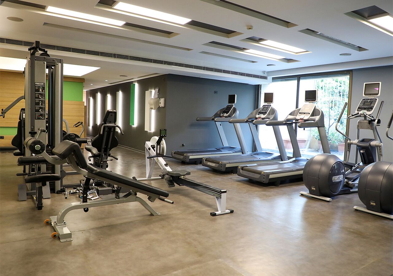 A gym with treadmills, elliptical machines, and weightlifting equipment.