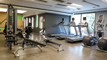 A gym with treadmills, elliptical machines, and weightlifting equipment.