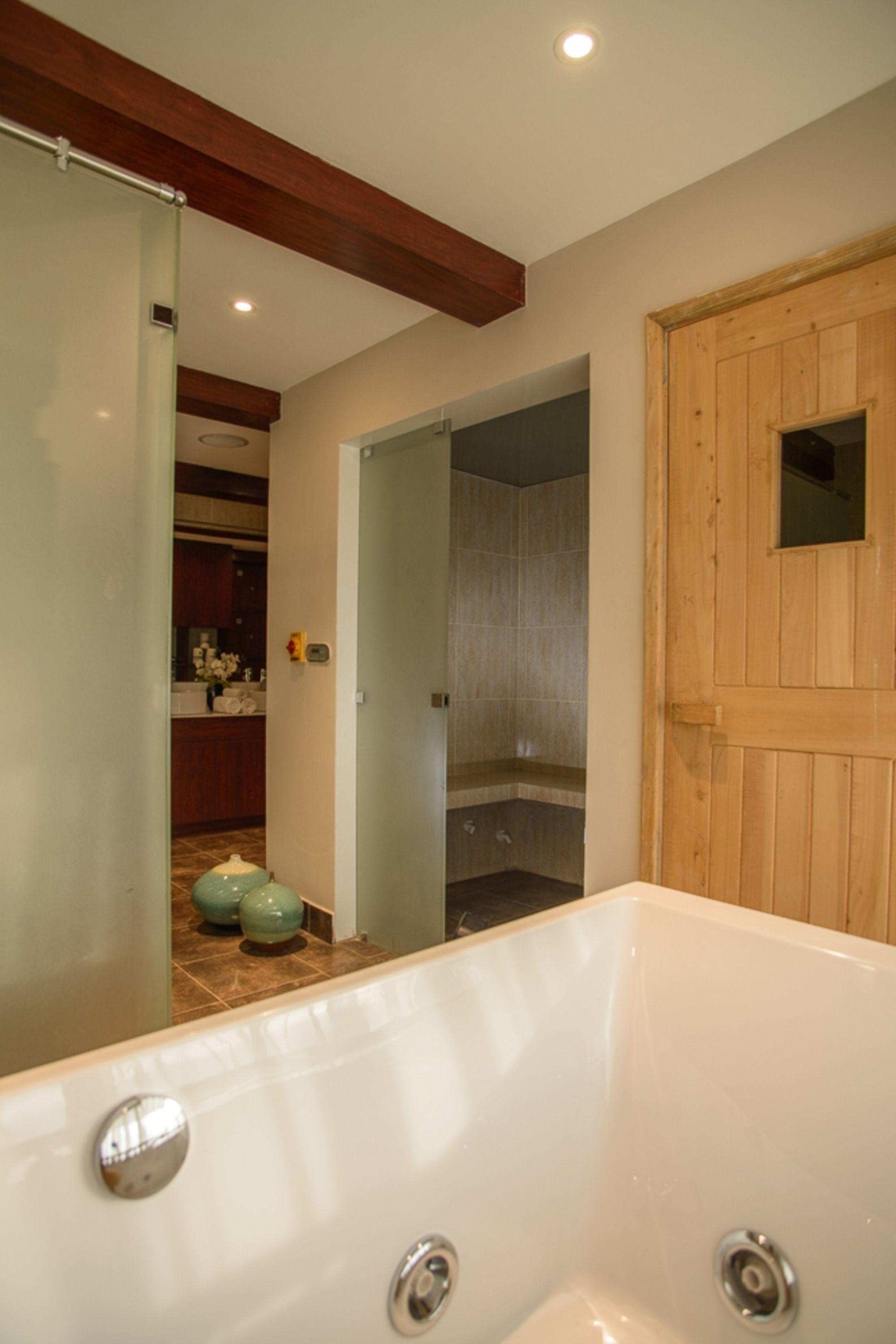 Une salle de bain avec une baignoire, une porte en bois et un espace douche.
