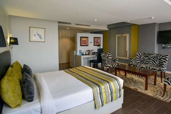 A hotel room with a bed, a desk, a chair, and a television. - Cloud Hotel & Suites (Nairobi)