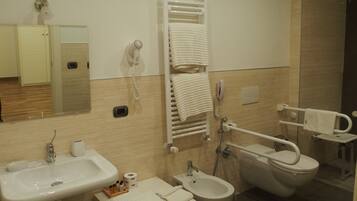 A modern bathroom with a sink, bidet, toilet, and towel rack.