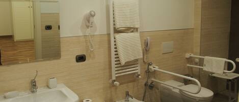 A modern bathroom with a sink, bidet, toilet, and towel rack.