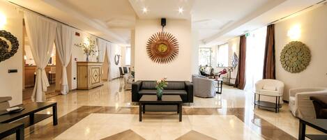 A spacious lobby with a central coffee table, seating area, and decorative wall art.