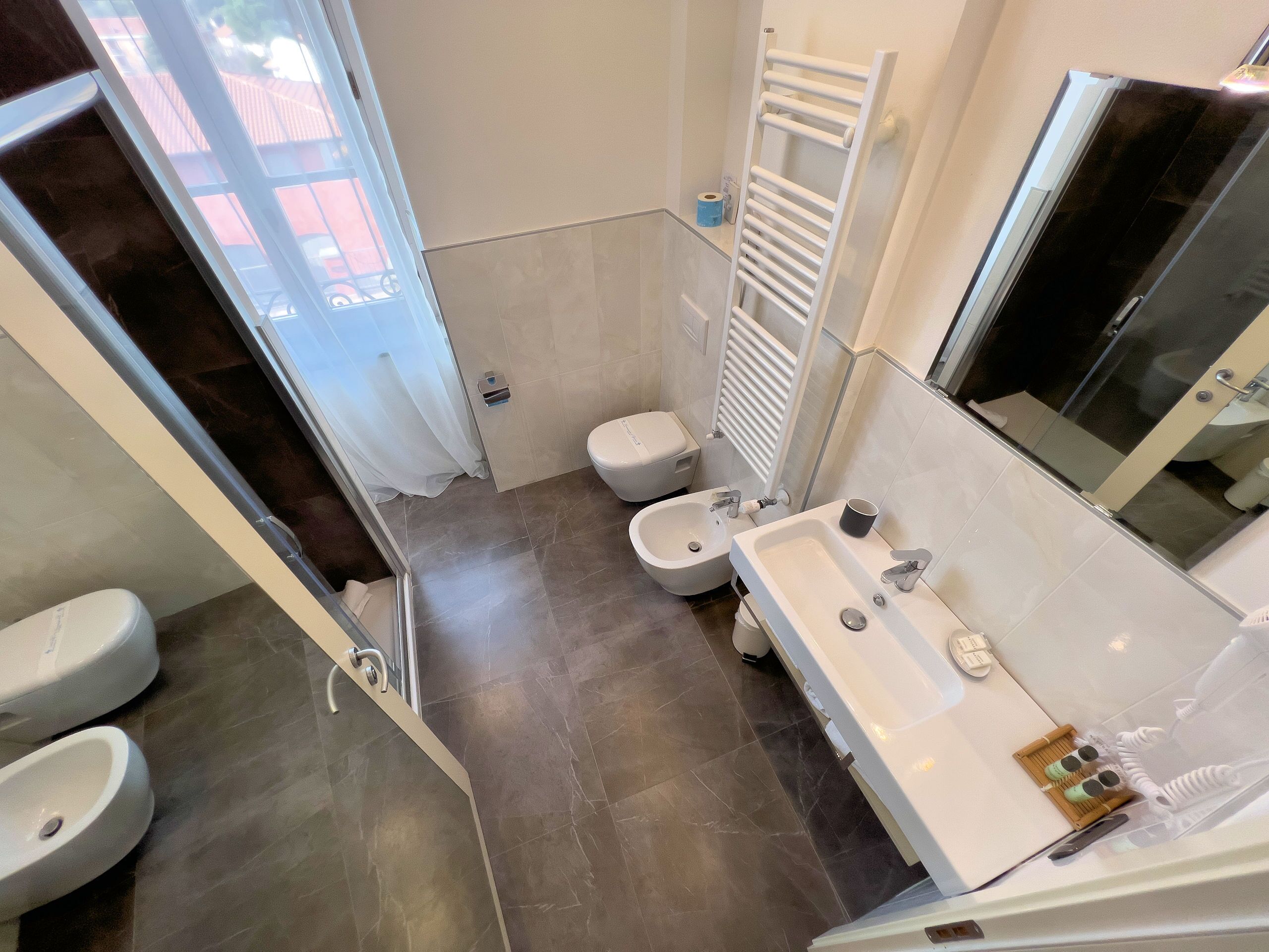 Een moderne badkamer met douche, toilet, wastafel en bidet.