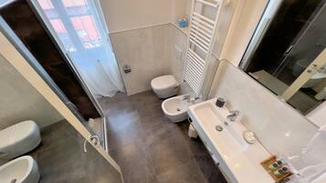 Een moderne badkamer met douche, toilet, wastafel en bidet.