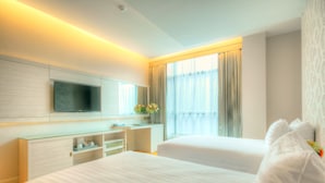 A hotel room with two beds, a flat-screen TV mounted on the wall, a glass desk, and a large window with curtains. - One One Bangkok Hotel (Bangkok)