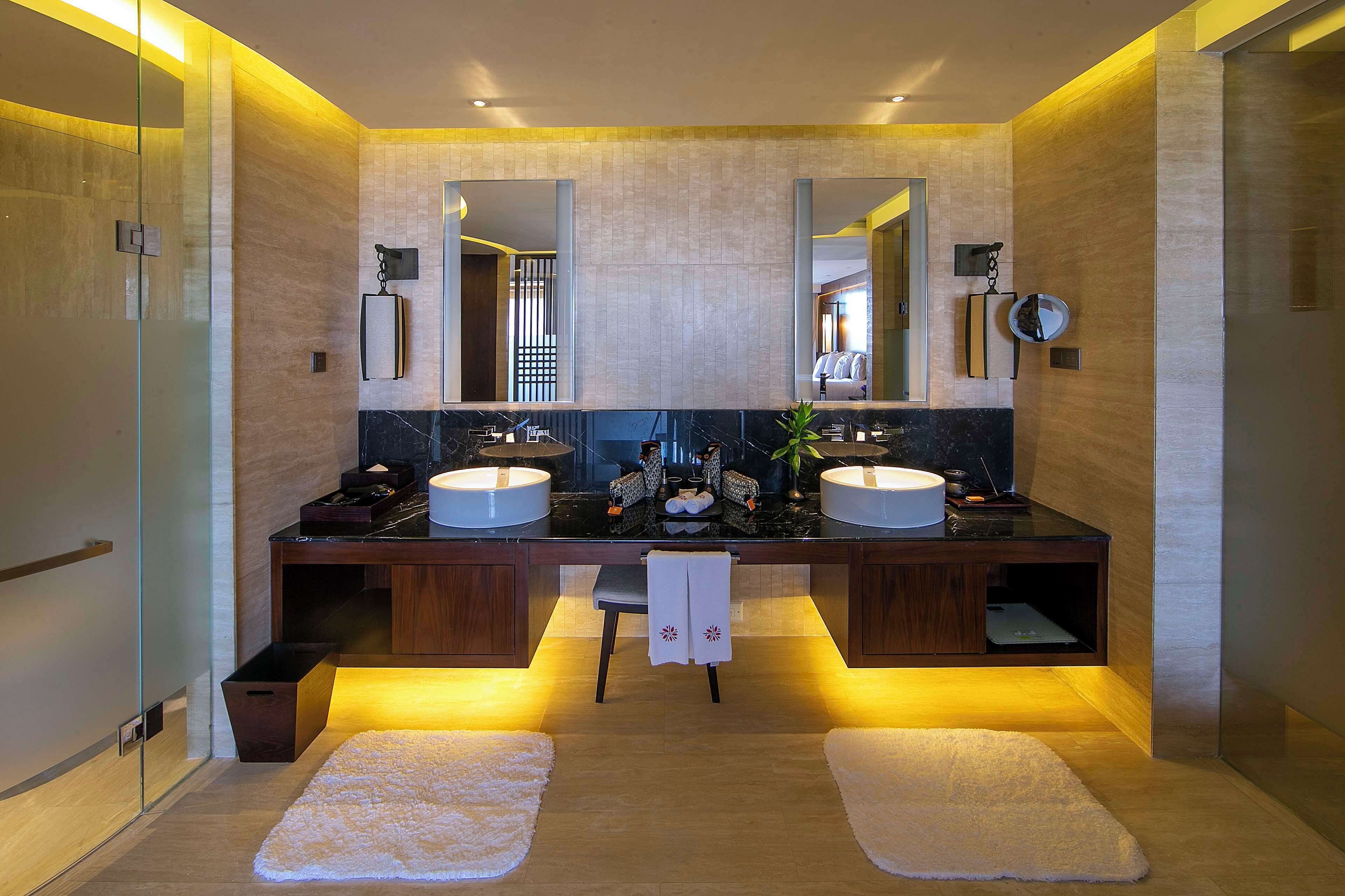 A modern bathroom with two sinks, a large mirror, and a glass shower enclosure.