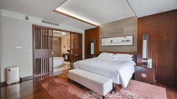 Un dormitorio moderno con una cama grande, un banco, una mesita de noche y una pared de paneles de madera.