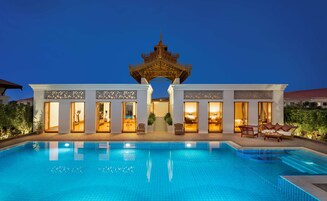 Una piscina al aire libre, sillones reclinables de piscina