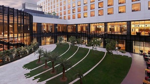 A modern hotel with a courtyard, multiple floors, and large windows.
