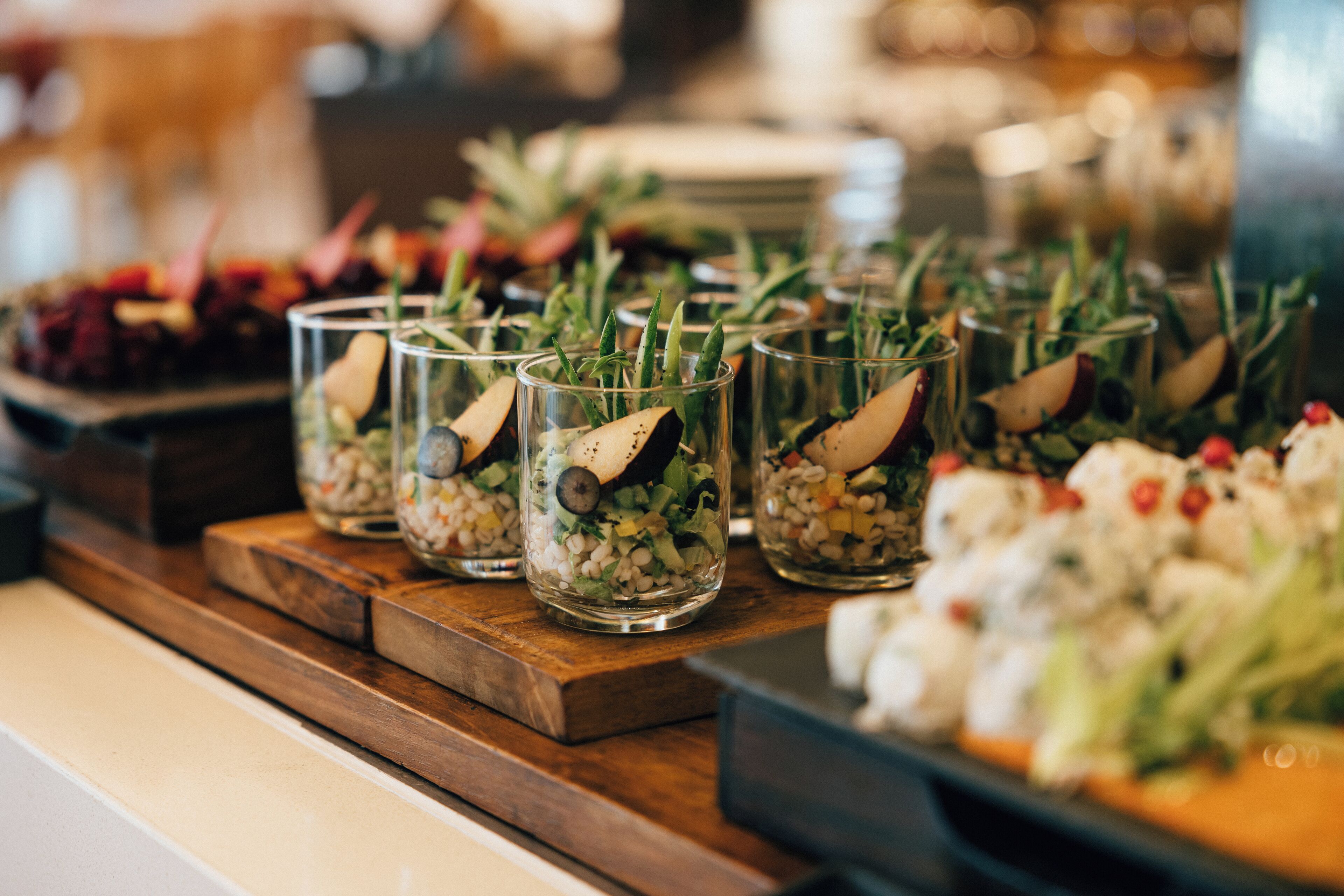 A buffet with various dishes, including salads and appetizers, arranged on wooden boards.