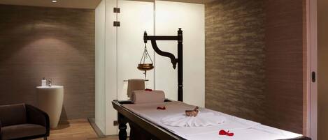 A modern room with a bed, a chair, a small table, and a scale.