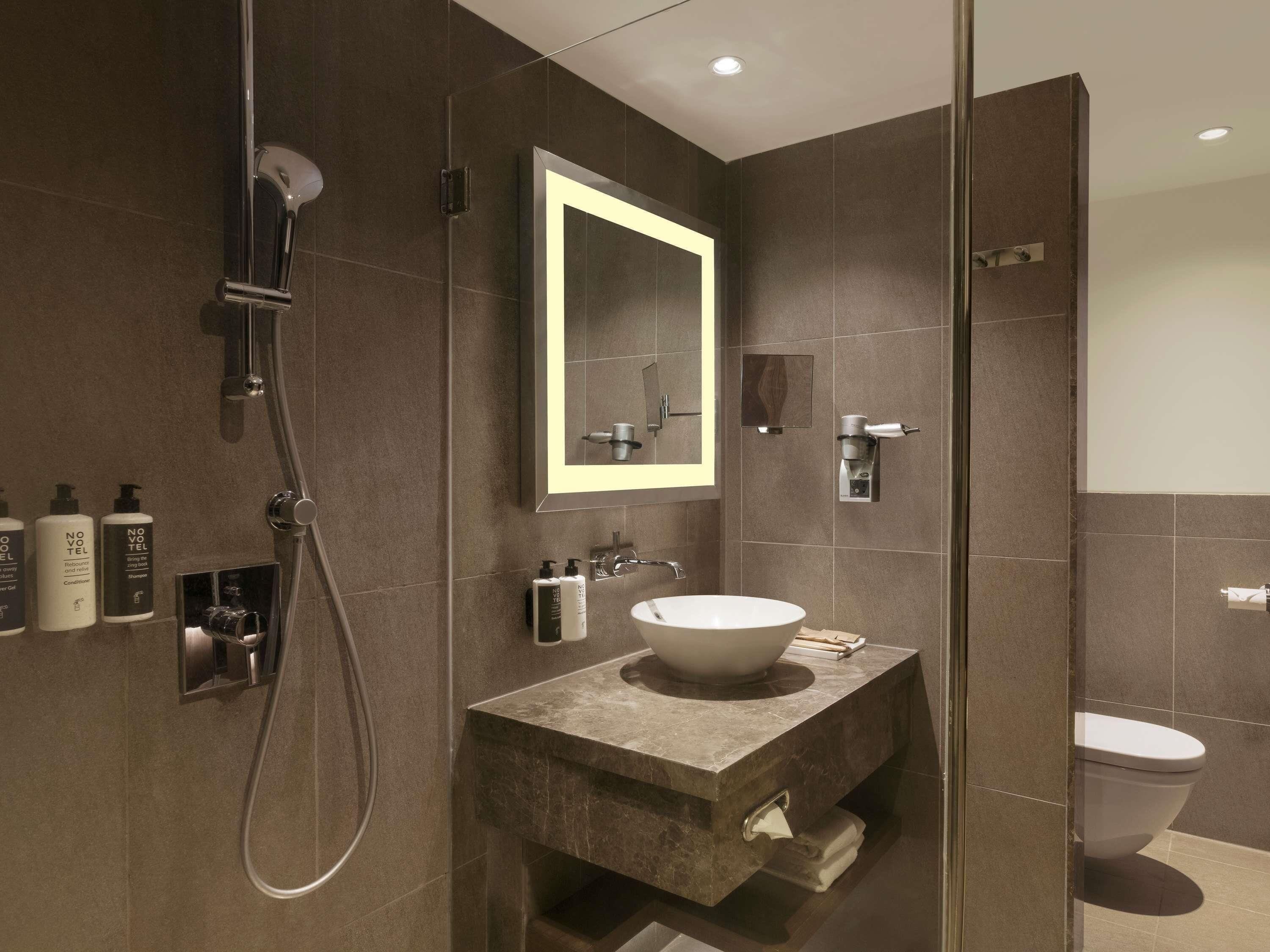 A modern bathroom with a shower, a sink, and a toilet.