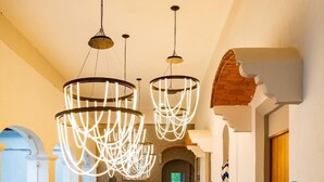 A modern hotel lobby with a wooden reception desk, a staircase, and a glass railing overlooking the lobby. - Hotel Ex hacienda Chautla Puebla, Trademark by Wyndham (San Salvador el Verde)