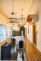 Un moderno vestíbulo de hotel con un mostrador de recepción de madera, una escalera y una barandilla de cristal con vistas al vestíbulo.